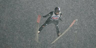 Andreas Wellinger fliegt in diochtem Schneegestäber durch die Luft