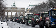 Traktoren fahren bei winterlichem Wetter vor dem Brandenburger Tor auf