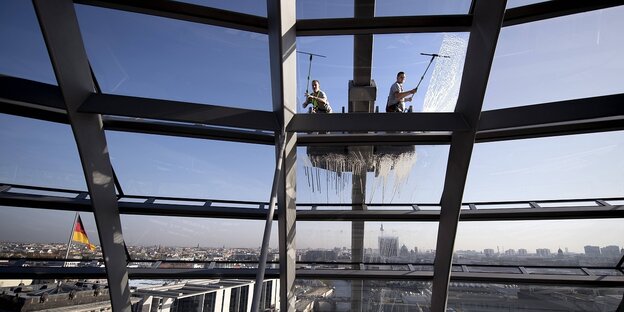 Zwei Fensterputzer putzen die Reichstagskuppel