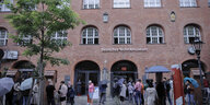 Deutsches Technikmuseum, Besucher mit Regenschirm stehen davor