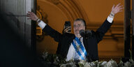 Mit der umgelegten Präsidentenschärpe winkt Bernardo Arévalo von einem Balkon