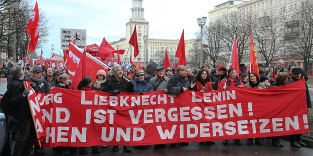 Mehrere Demonstrierende bei auf der Frankfurter Allee mit roten Fahnen