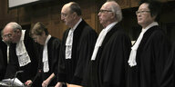 Fünf RichterInnen in schwarzer Robe und weissem Halsband stehen an der Richterbank