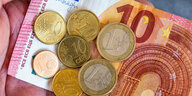 Geldscheine und Euromünzen mit dem Wert von 12,41 Euro liegen auf einer Hand