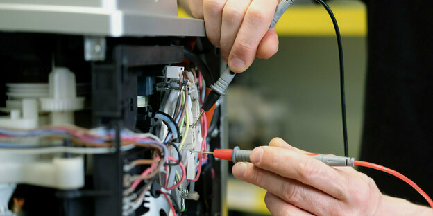 An einem Kaffee-Vollautomaten in einer Reparaturwerkstatt werden elektronische Messgrößen ermittelt.