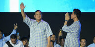 Prabowo Subianto steht auf einer Bühne und winkt.
