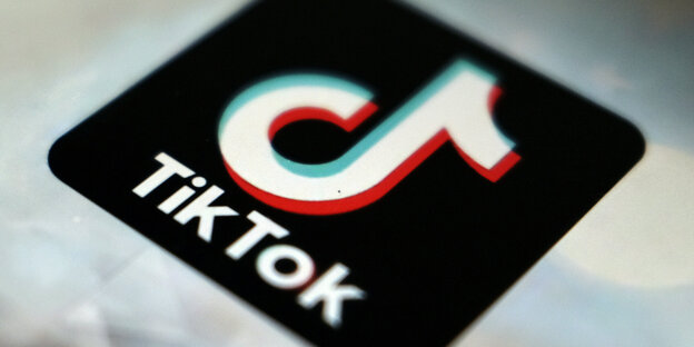 Das Logo von Tiktok: Eine schwarze Kachel mit einm weißen d, das gleichzeitig eine stilisierte Musiknote ist. Darunter steht in weiß "TikTok".