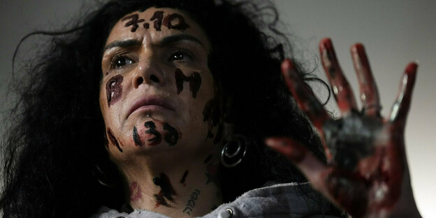 Eine Frau, die das Datum 7.10. mit blutroter Farbe auf ihre Stirn geschrieben hat, fordert die Freilassung der Geiseln der Hamas