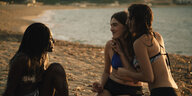 Drei Mädchen unterhalten sich in der Abendsonne am Strand