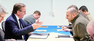 Verteidigungsminister Pistorius und sein ukrainischer Amtskollege Umjerow sitzen sich gegenüber an einem langen Tisch und diskutieren