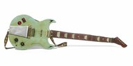 eine hellgrüne mit Metal-Aufklebern beklebte Spielzeug-E-Gitarre