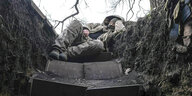Ein Soldat schläft in einem Schützengraben