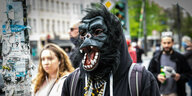 Person mit einer Gorilla-Maske auf dem Kopf steht auf der Straße