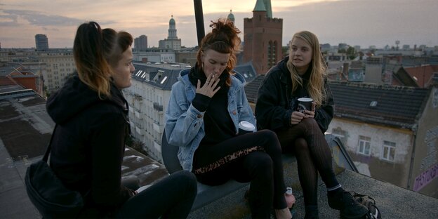 Drei Menschen sitzen aufm Dach in der Liebigstraße in Berlin-Friedrichshain: eine Szene aus dem Dokumentarfilm „Berlin Untopiekadaver“