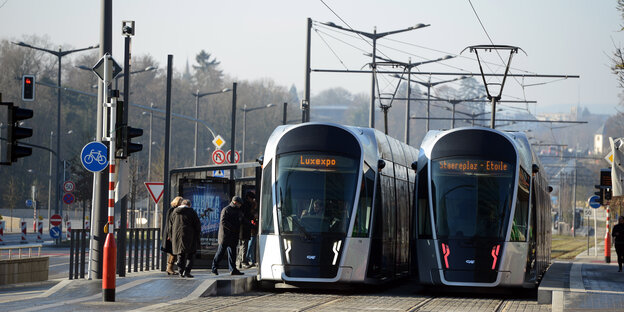 Zwei Trams stehen an einer Haltestelle im Bankenviertel Kirchberg in Luxemburg.