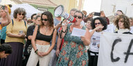 Bewohner Tneriffas stehen mit einem Mefafon und Plakat auf einem Platz und demonstrieren gegen die Auswüchse des Tourismus auf der Insel