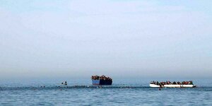 Vollbesetzte Flüchtlingsboote und im Meer schwimmende Menschen sind am 15.04.2017 rund 20 Meilen vor der Küste von Libyen zu sehen.