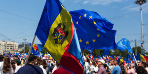 Demonstranten schwenken Flaggen der Europäischen Union und der Republik Moldau.
