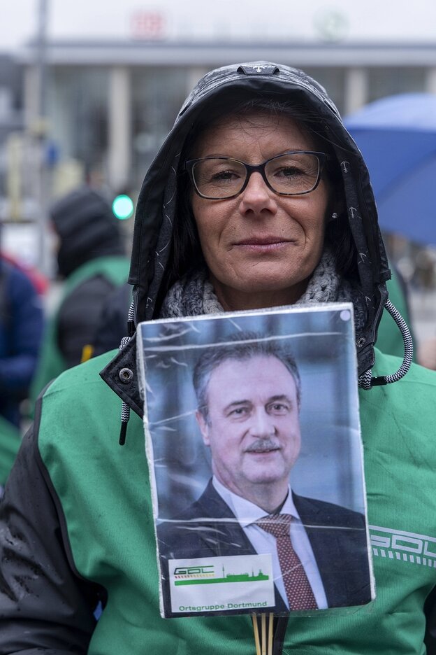 Eine Frau trägt ein Schild mit dem Foto von Klaus Weselsky