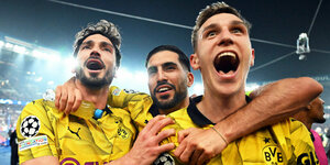 Drei Dortmunder Spielen un engner Umarmung mit Blick nach vorne