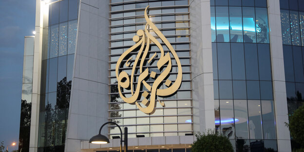 Blick auf ein Gebäude, darauf groß und golden das Logo des Nachrichtensenders Al-Jazeera