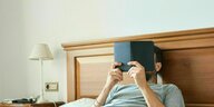 Ein Mann liest im Bett ein Buch