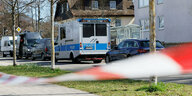 Polizeifahrzeuge und Absperrband an einem Tatort