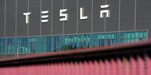 Das Foto zeigt den Schriftug des US-Autobauers Tesla an der Fassade seiner Fabrik in Grünheide östlich von Berlin