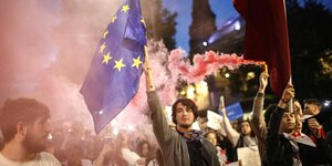 Protestierende in rosa Rauch mit EU-Flaggen