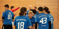 Fußballteam mit blauen Trikots in der Halle beim Gespräch