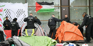 Polizeibeamte bauen nach der Räumung eines pro-palästinensischen Camps die verbliebenen Zelte ab