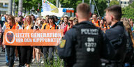 Mitglieder der Letzten Generation demonstrieren unter Aufsicht der Polizei.