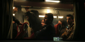 Menschen in einem Bus, von außen bei Nachr fotografiert