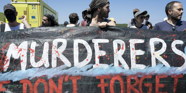 Demonstranten mit einem Banner, auf dem Murderes steh,t nach dem Schiffunglück von Pylos