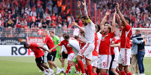 Unions Spieler jubeln nach dem Sieg gegen Freiburg mit ihren Fans.