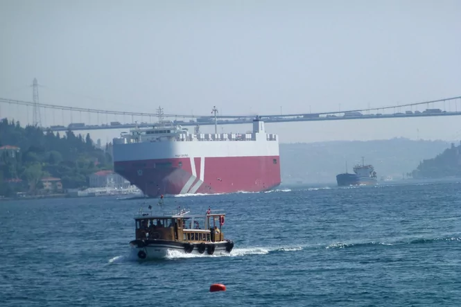 Der Bosporus: Im Vordergrund ein kleines Fischerboot, im Hintergrund ein Tanker und die Bosporus-Brücke
