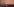 Hinter der Skyline Manhattans mit erleuchteten Fenster zeigt sich ein rosiger Sonnenuntergang.
