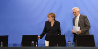 Angela Merkel und Winfried Kretschmann stehen vor einem Tisch