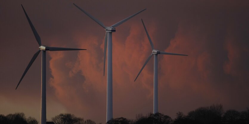 Windräder vor rot gefärbten Wolken