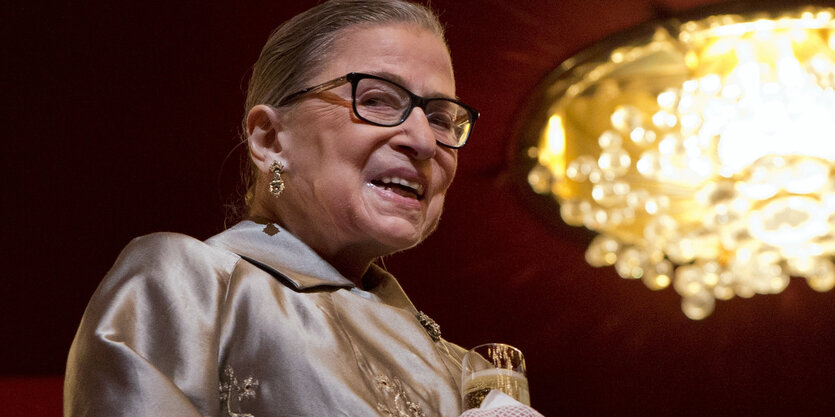 Eine Frau mit Brille in einem festlichen Blazer, es ist Ruth Bader Ginsburg