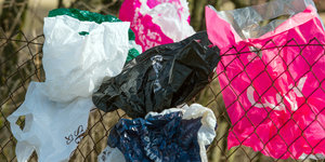 Plastiktüten hängen in einem Zaun