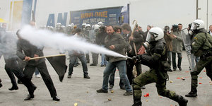 Polizisten gehen mit Tränengas gegen demonstrierende Landwirte im Hafen von Piräus vor.
