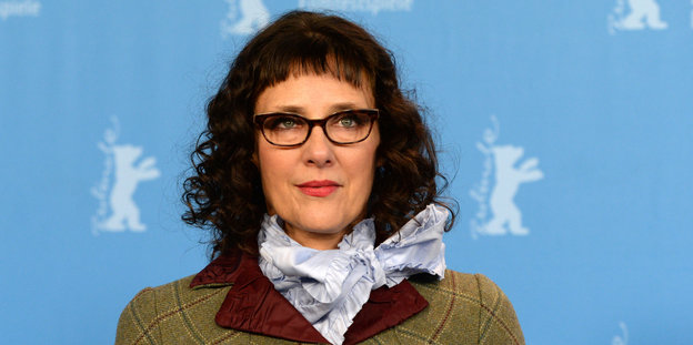 eine Frau mit Brille vor blauen Hintergrund mit Berlinale Bären