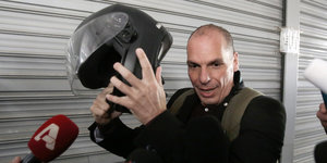 Gianis Varoufakis mit Motorradhelm in der Hand.