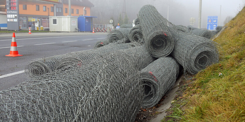 Rollen von Drahtzäunen liegen neben einer Straße