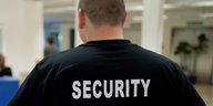 Ein Mann trägt ein Hemd mit der Aufschrift Security