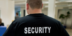 Ein Mann trägt ein Hemd mit der Aufschrift Security