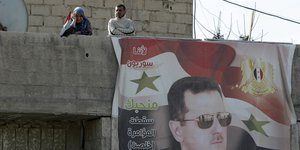 Eine Frau, ein Mann, ein riesiges Assad-Plakat