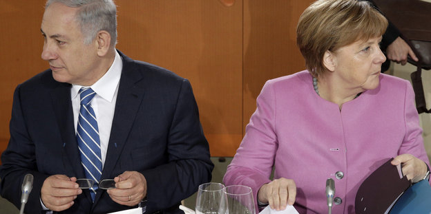 Benjamin Netanjahu schaut nach links, Angela Merkel nach rechts