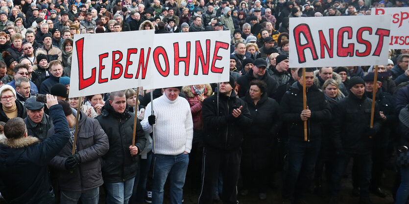 Demonstranten halten Schilder mit den Worten „Leben ohne Angst“ in die Höhe